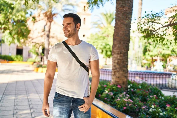 Parkta kendinden emin gülümseyen İspanyol genç adam.