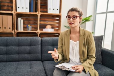 Genç sarışın kadın psikolog psikoloji merkezinde danışmanlık yapıyor.