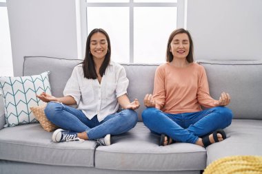 Evde yoga yapan iki kadın anne ve kız.