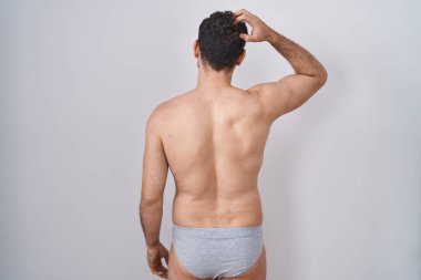 İspanyol asıllı genç adam iç çamaşırlarını ters giyip elleri kafasında şüpheyi düşünüyor. 