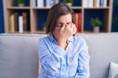 Orta yaşlı İspanyol bir kadın evdeki kanepede oturuyor. Burnu ve gözleri ovuşturup yorgunluk ve baş ağrısı çekiyor. Stres ve hüsran kavramı. 