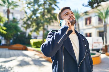 Parkta kollarını kavuşturmuş İspanyol genç bir adam.