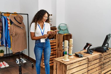 Genç Latin esnaf mağazasında çalışırken gülümsüyor..