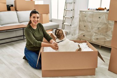 Evde köpekle oynarken kendine güvenen genç bir kadın.