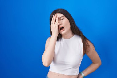 Mavi arka planda duran beyaz bir kadın. Yarı yüz, göz ve ağız kaplamasından yorgun düşmüş. Yüzüm acıyor.. 