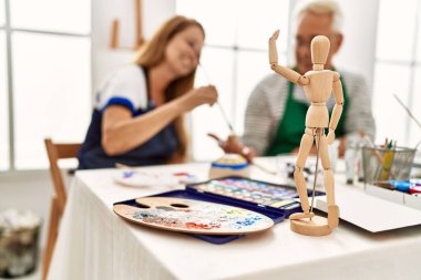 Sanat stüdyosunda mutlu mesut resim yapan iki orta yaşlı sanatçı..