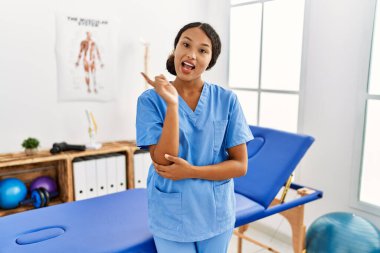 Güzel İspanyol fizyoterapist kadın. Ağrı kesici kliniğinde. Yüzünde kocaman bir gülümseme var.. 