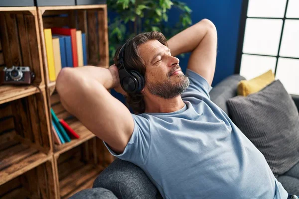 Mężczyzna Średnim Wieku Słuchając Muzyki Zrelaksowany Kanapie Domu — Zdjęcie stockowe