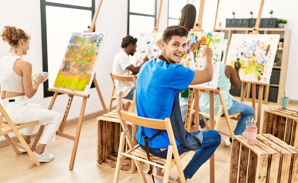 アートスタジオで笑顔で絵を描く人々のグループ — ストック写真