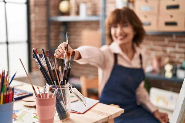 Mujer Mediana Edad Artista Sonriendo Confiado Sosteniendo Paintbrushe Estudio Arte —  Fotos de Stock