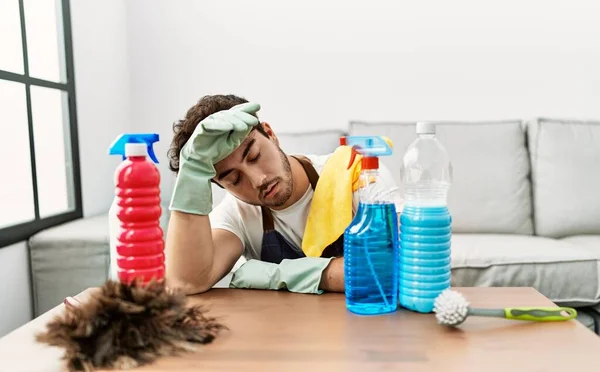 Joven Hispano Cansado Apoyado Mesa Con Productos Limpieza Casa — Foto de Stock