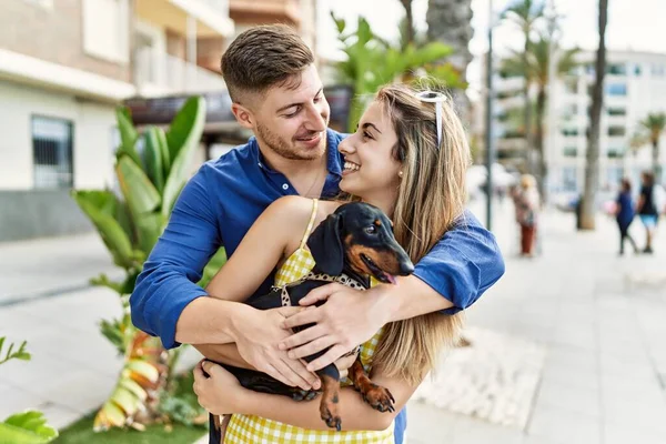 Jovem Casal Caucasiano Sorrindo Feliz Abraçando Com Cão Passeio — Fotografia de Stock