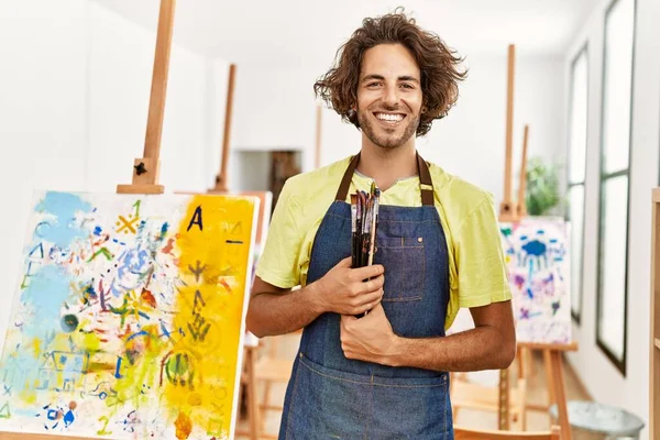 Jovem Artista Hispânico Homem Sorrindo Feliz Segurando Pincéis Estúdio Arte — Fotografia de Stock