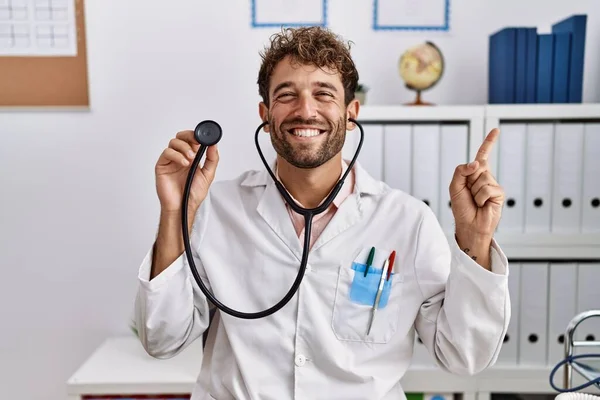 Young Hispanic Doctor Man Wearing Doctor Uniform Holding Stethoscope Clinic — Stock Photo, Image
