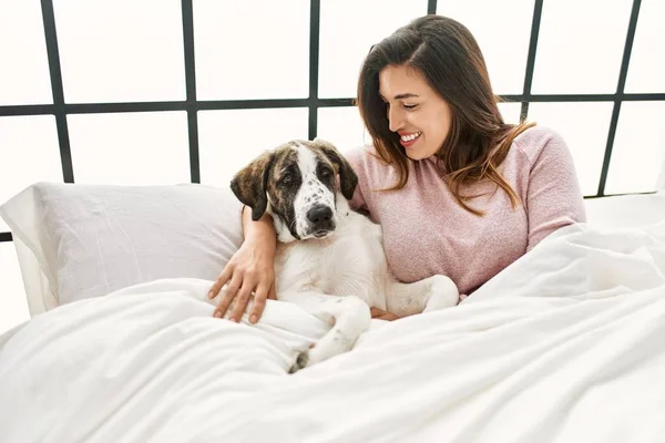 Junge Frau Lächelt Selbstbewusst Und Umarmt Hund Der Auf Bett — Stockfoto