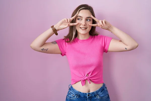 Mujer Rubia Caucásica Pie Sobre Fondo Rosa Haciendo Símbolo Paz —  Fotos de Stock