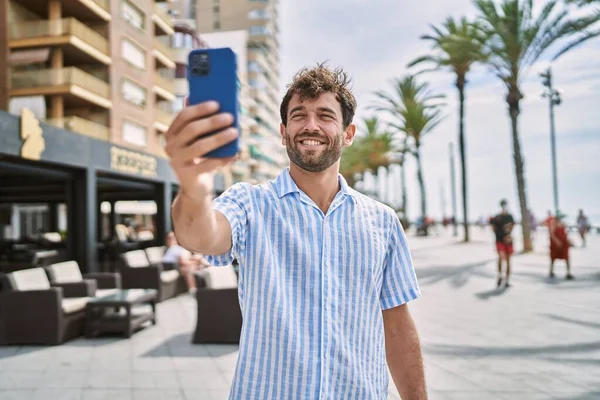 Ung Latinamerikansk Man Ler Lycklig Stående Vid Strandpromenaden — Stockfoto