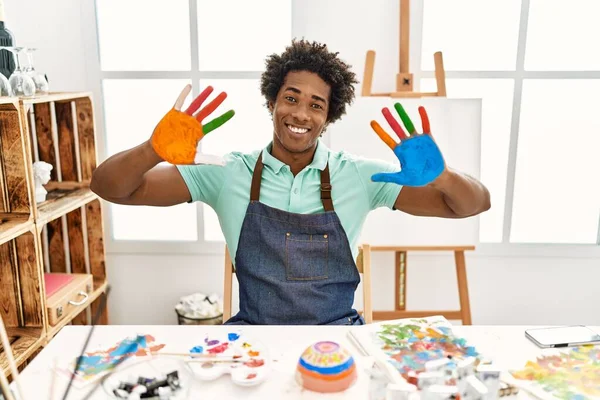 若いアフリカ系アメリカ人アーティストの男笑顔幸せなショー色ヤシの手でアートスタジオ — ストック写真