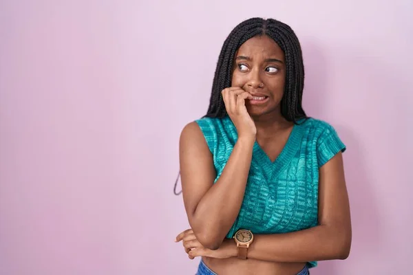 Jovem Afro Americana Com Tranças Sobre Fundo Rosa Olhando Estressado — Fotografia de Stock