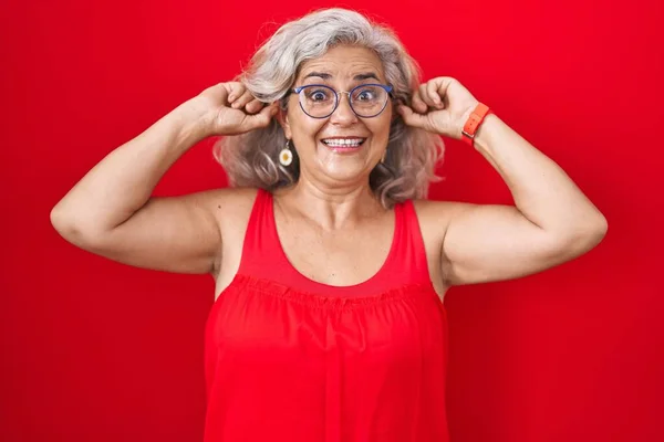 Kırmızı Arka Planda Gri Saçlı Orta Yaşlı Bir Kadın Gülümsüyor — Stok fotoğraf