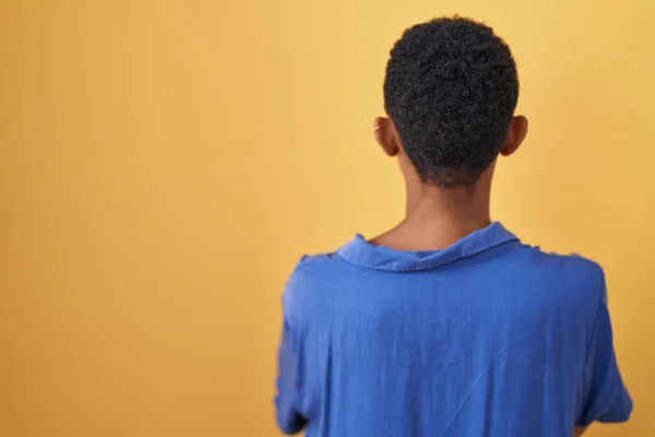 Африканская Американка Стоит Жёлтом Фоне Смотрит Назад Скрестив Руки — стоковое фото