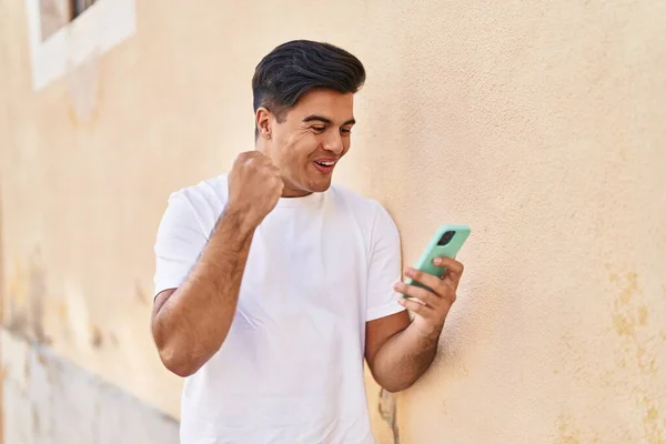 年轻人在街上用带有赢家表情的智能手机 — 图库照片