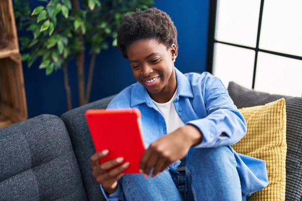 African American Γυναίκα Χρησιμοποιώντας Touchpad Κάθεται Στον Καναπέ Στο Σπίτι — Φωτογραφία Αρχείου