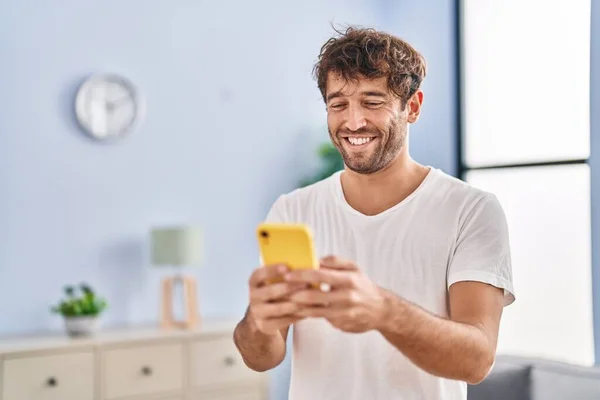 Genç Adam Evde Akıllı Telefon Kullanarak Kendinden Emin Gülümsüyor — Stok fotoğraf