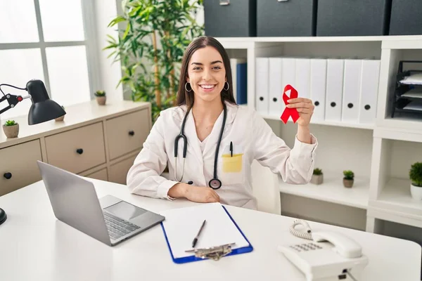 Latynoska Lekarz Kobieta Trzyma Wsparcie Czerwona Wstążka Patrząc Pozytywnie Szczęśliwy — Zdjęcie stockowe