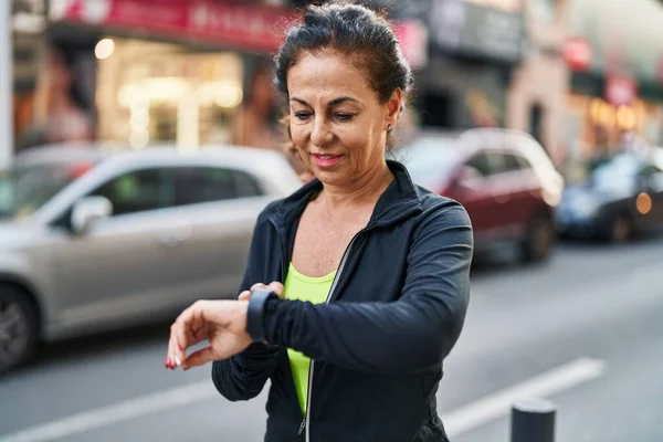 Middle Age Hispanic Woman Working Out Smart Watch Outdoors — ストック写真