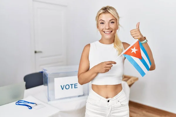 政治選挙で若い白人女性キューバの旗を保持します笑顔と正 親指アップ優れたと承認サインを行います — ストック写真
