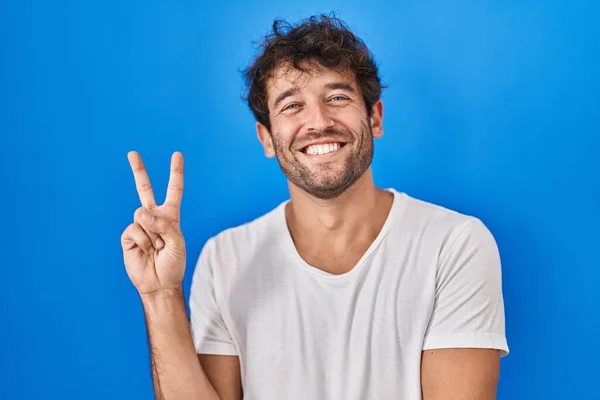 Spaanse Jongeman Die Een Blauwe Achtergrond Staat Glimlachen Met Een — Stockfoto