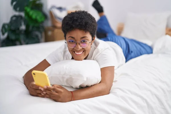African American Woman Using Smartphone Lying Bed Bedroom —  Fotos de Stock