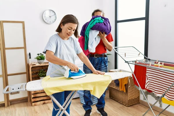 Medelålders Man Och Kvinna Par Ler Säker Strykning Kläder Vid — Stockfoto