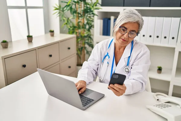 Μεσήλικη Γυναίκα Που Φοράει Ιατρική Στολή Χρησιμοποιώντας Smartphone Στην Κλινική — Φωτογραφία Αρχείου