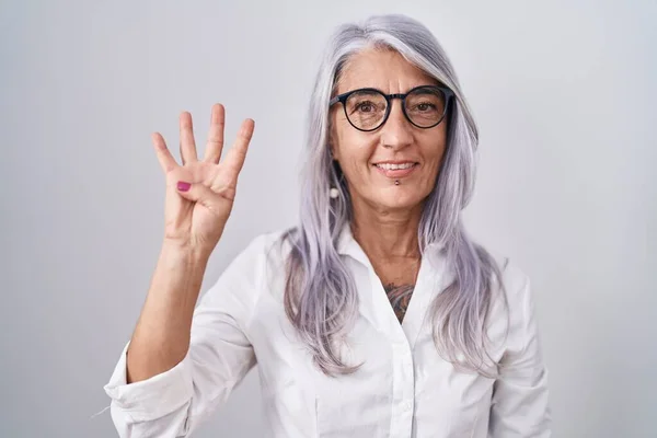 Beyaz Arka Planda Duran Gözlüklü Orta Yaşlı Bir Kadın Dört — Stok fotoğraf