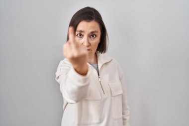 Middle age hispanic woman standing over isolated background showing middle finger, impolite and rude fuck off expression 