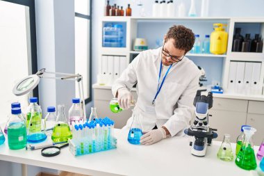 Genç İspanyol bilim adamı laboratuvarda sıvıyı ölçüyor.