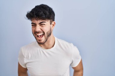 Beyaz arka planda sakallı İspanyol bir adam öfkeli ve öfkeli bağırıyor öfkeyle bağırıyor. öfke ve agresif konsept. 
