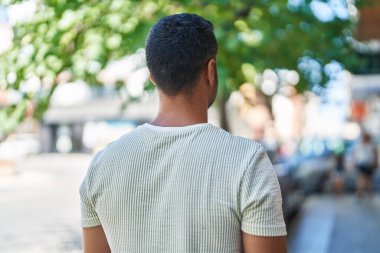 Rahat yüzü olan genç bir İspanyol sokak manzarasında dikiliyor.