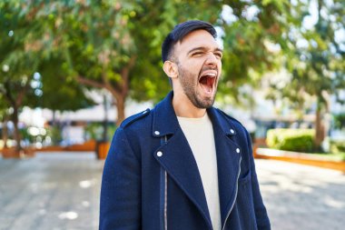 Genç İspanyol adam parkta bağırıyor.