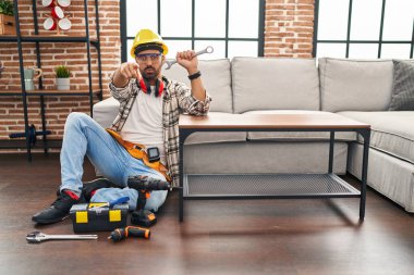 Sakallı, hareket servisi için çalışan, kamerayı işaret eden, kendine güvenen, ciddi bir jest yapan genç bir İspanyol. 