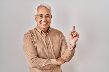 Gözlüklü, yüzünde kocaman bir gülümseme olan İspanyol asıllı son sınıf öğrencisi, kameraya el ve parmağıyla bakıyor.. 