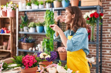 Genç, güzel, İspanyol bir çiçekçi çiçekçiye akıllı telefondan fotoğraf dikmiş.