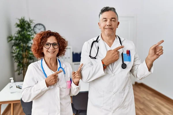 Dois Médicos Meia Idade Clínica Médica Sorrindo Olhando Para Câmera — Fotografia de Stock