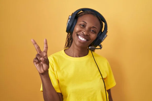 Mujer Afroamericana Escuchando Música Usando Auriculares Sonriendo Mirando Cámara Mostrando —  Fotos de Stock