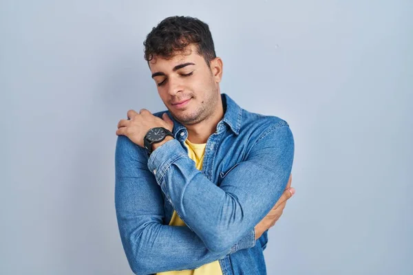 Mavi Arka Planda Duran Genç Spanyol Adam Kendine Sarılıyor Mutlu — Stok fotoğraf