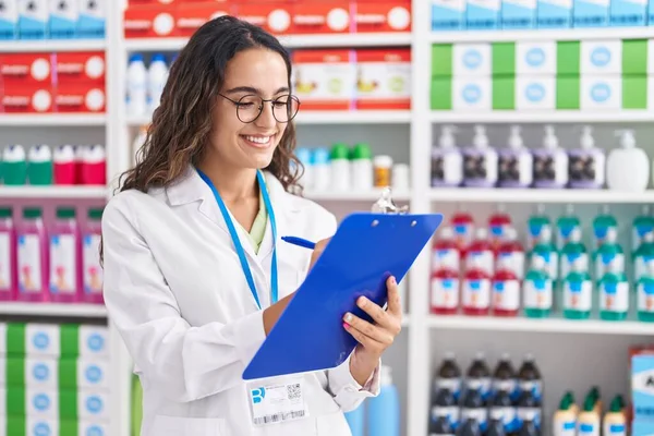 Jonge Mooie Spaanse Vrouw Apotheker Schrijven Klembord Bij Apotheek — Stockfoto