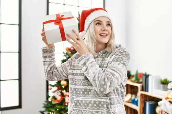 Junge Kaukasierin Lächelt Glücklich Und Trägt Weihnachtsmütze Mit Geschenk Hause — Stockfoto