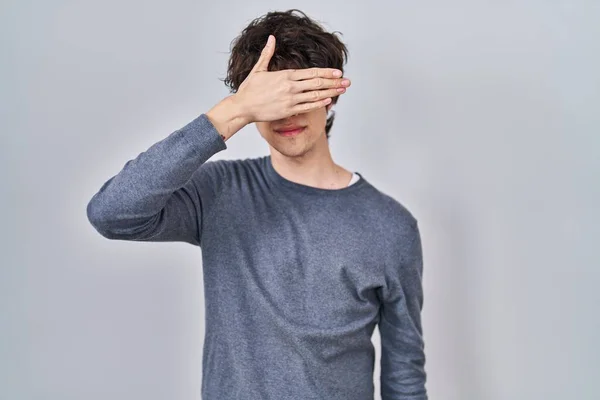 Mladý Muž Stojící Nad Osamělým Pozadím Zakrývající Oči Rukou Vypadal — Stock fotografie